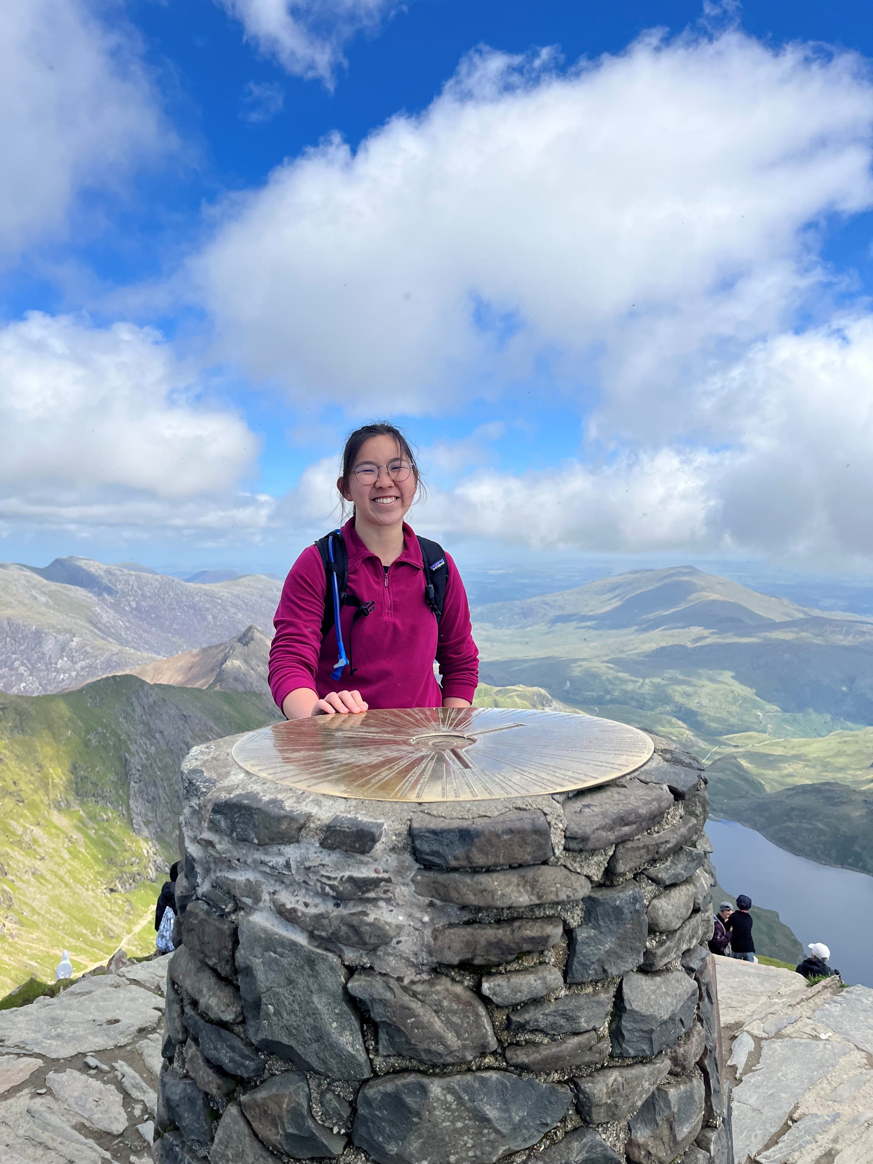 Lady with glasses standing at the summit of Snowdon